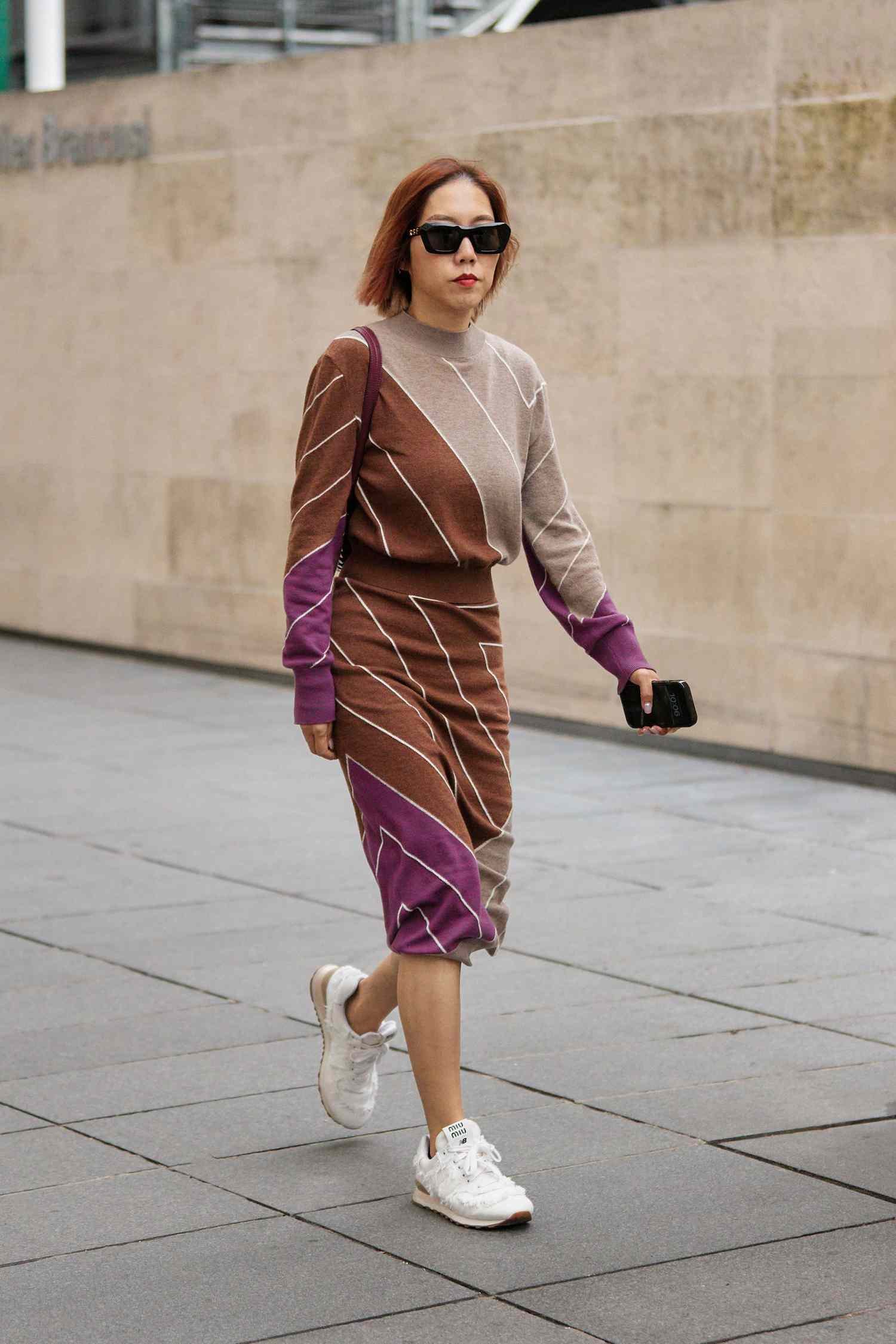 Person wears stripe brown, beige, and purple sweater dress