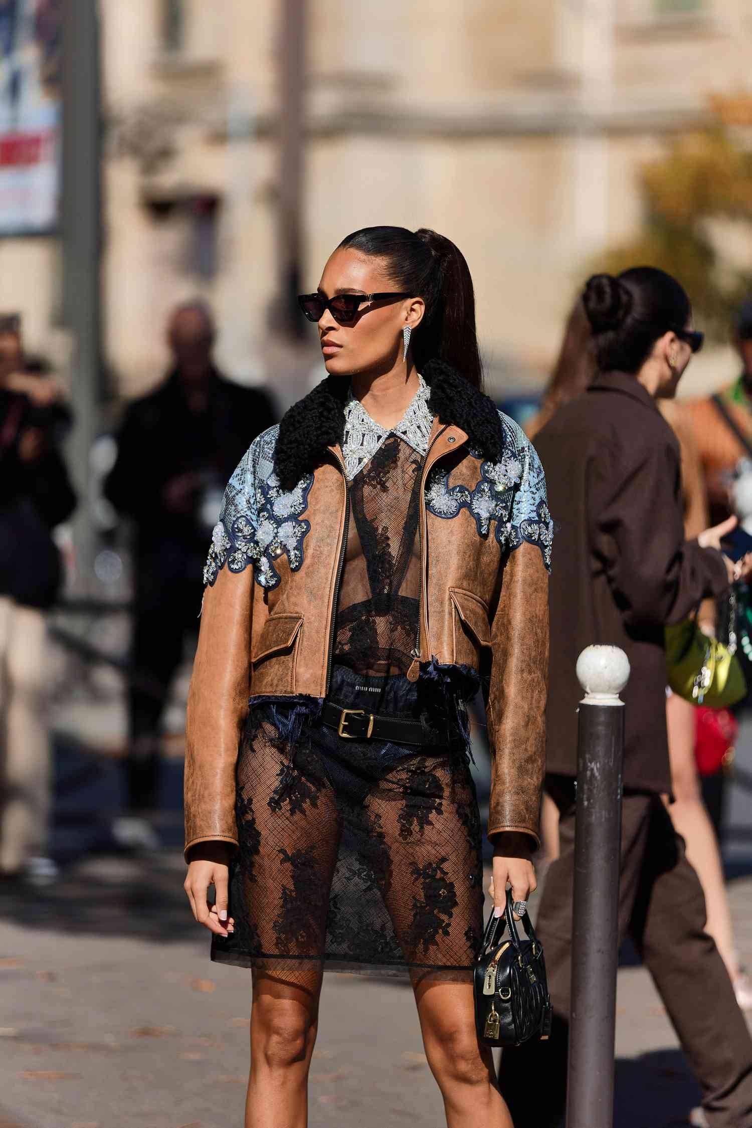 Person wear sheer inkiness dress with brown leather jacket