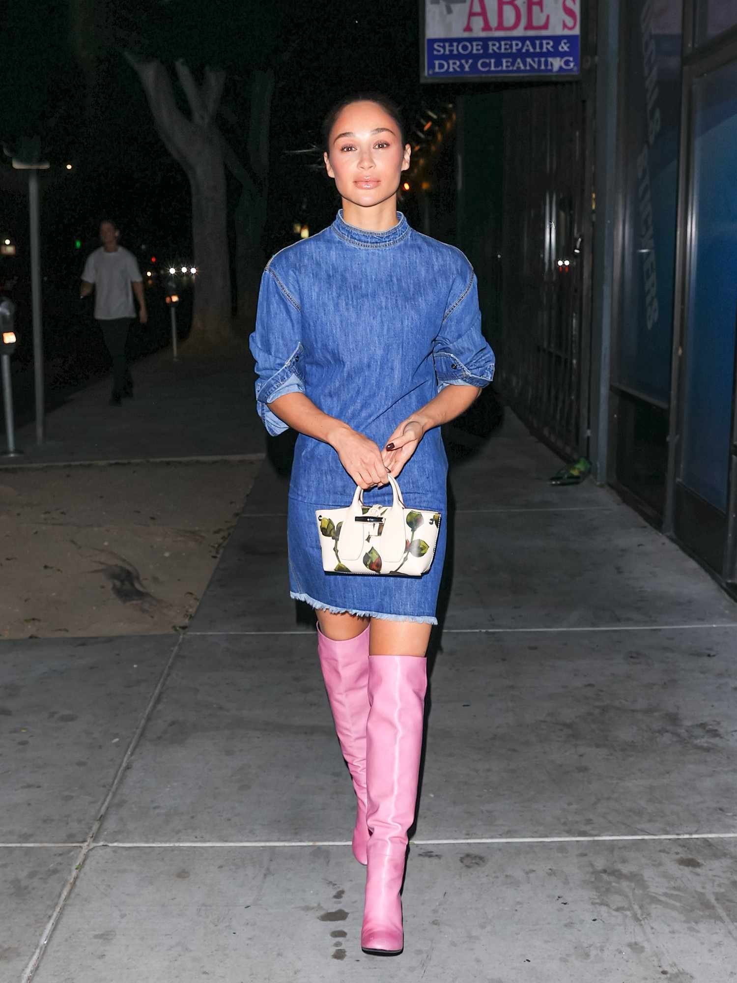 Wearing barbiecore thigh-high boots, Cara Santana shows how to wear over-the-knee boot with angstrom denim dress.