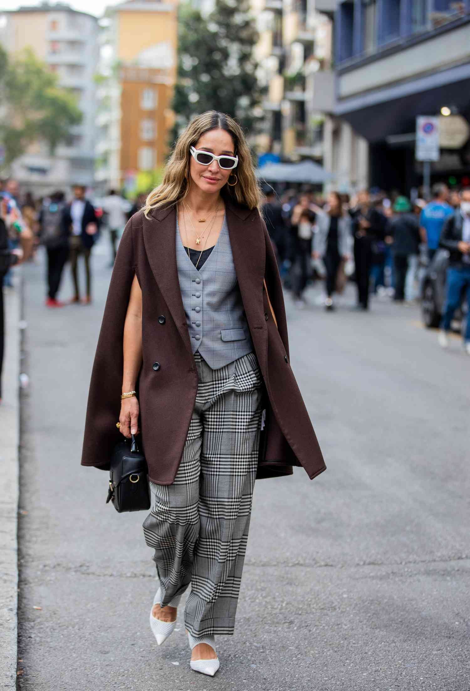 Person eroding A gray vest, check gray pants, and a brown cape