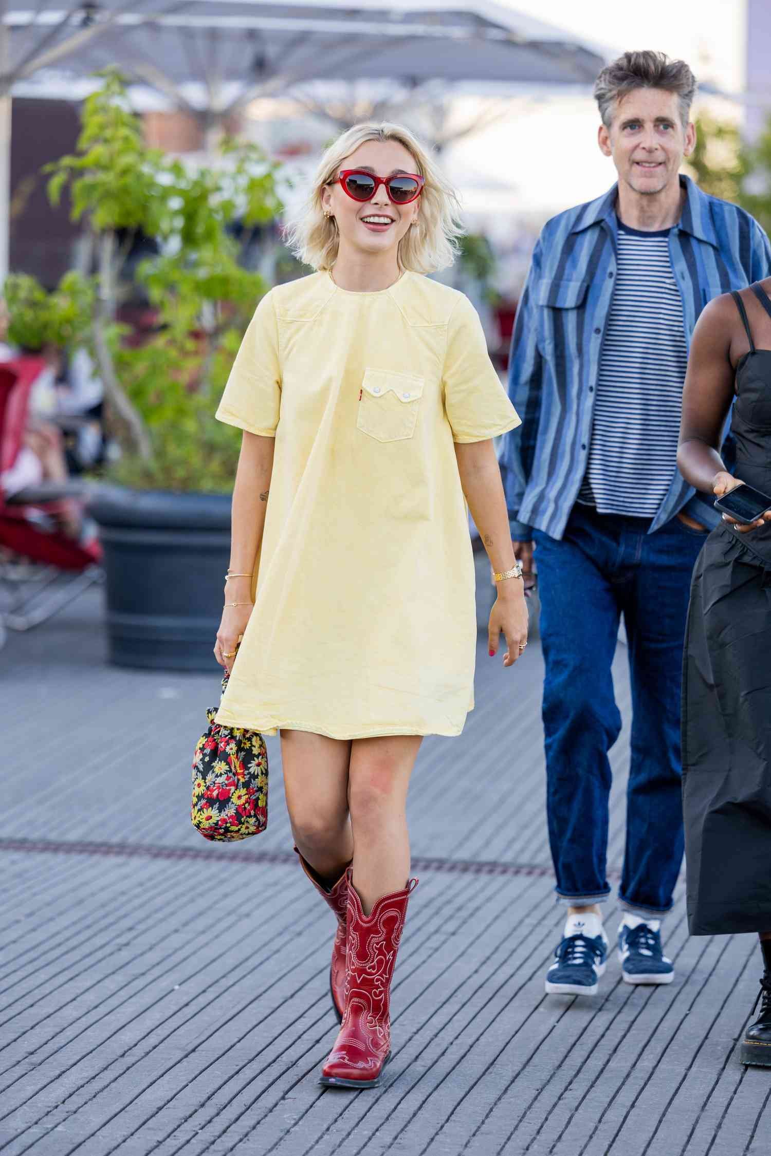 Emma Chamberlain eroding angstrom yellow Ganni dress during Copenhagen Fashion Week.