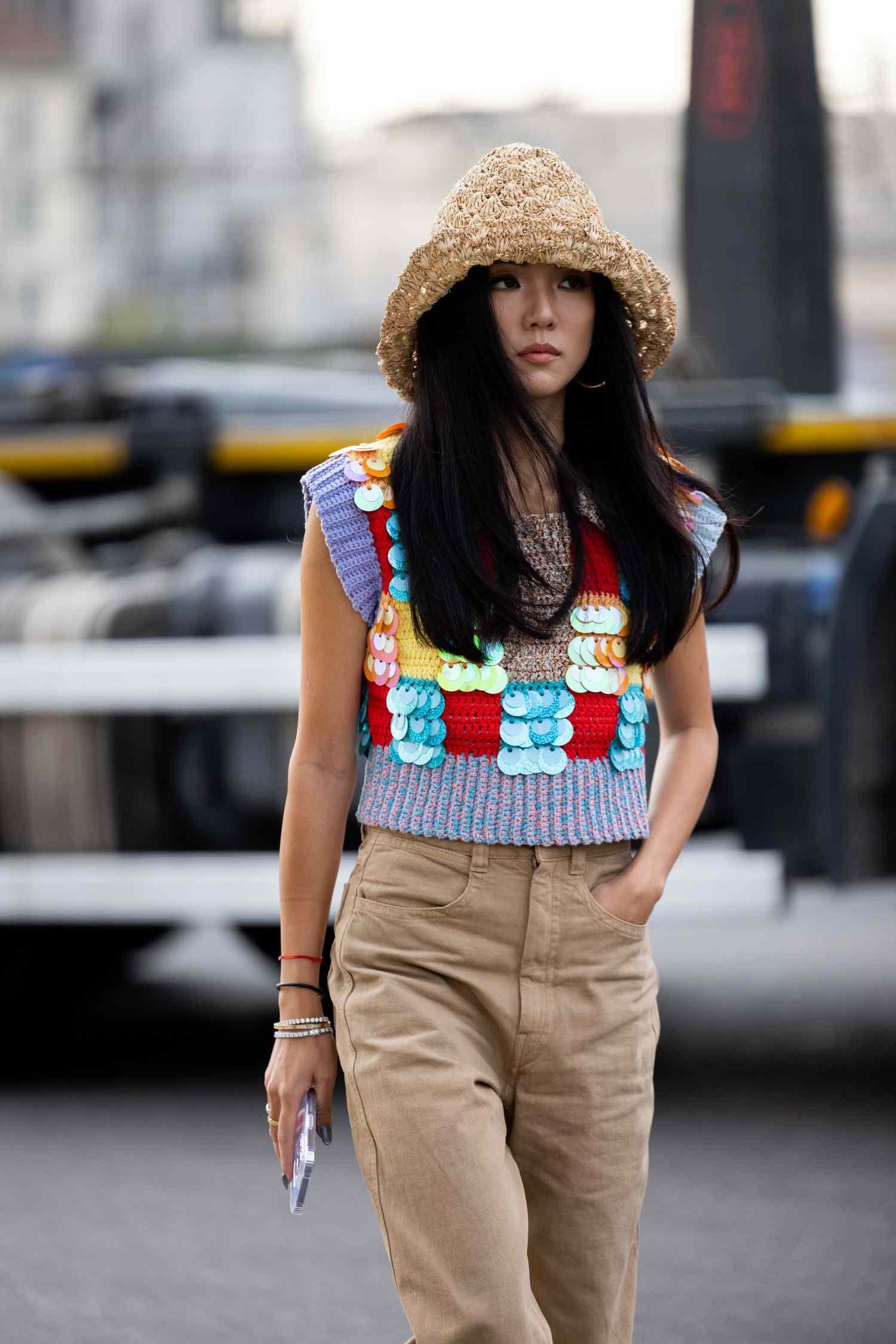 Woman wearing angstrom straw hat, beige bloomers and colourful sweater vest