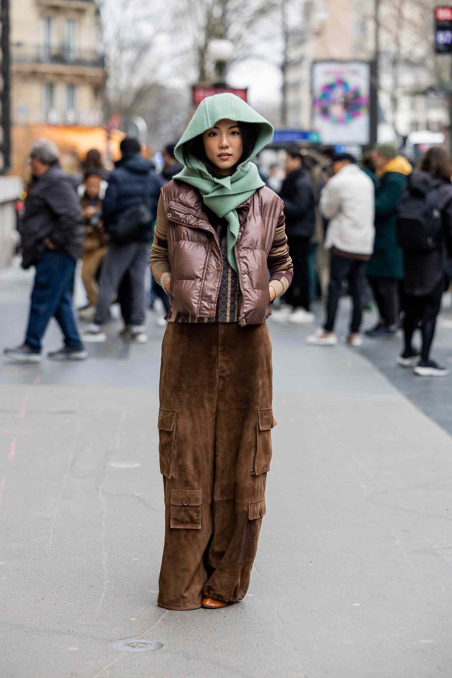 Person wearing brown cargo pants, a puffer vest, and green head scarf