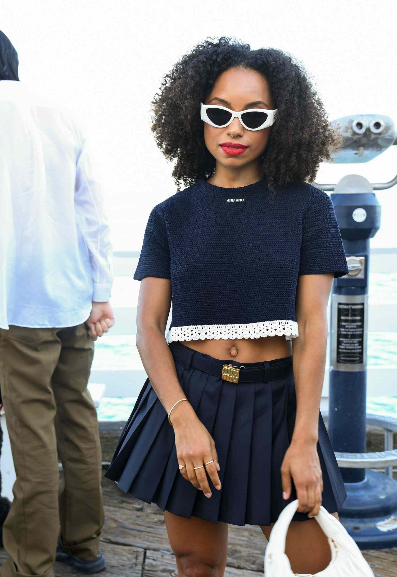 Logan Browning wearing a navy Miu Miu crop top and pleat skirt