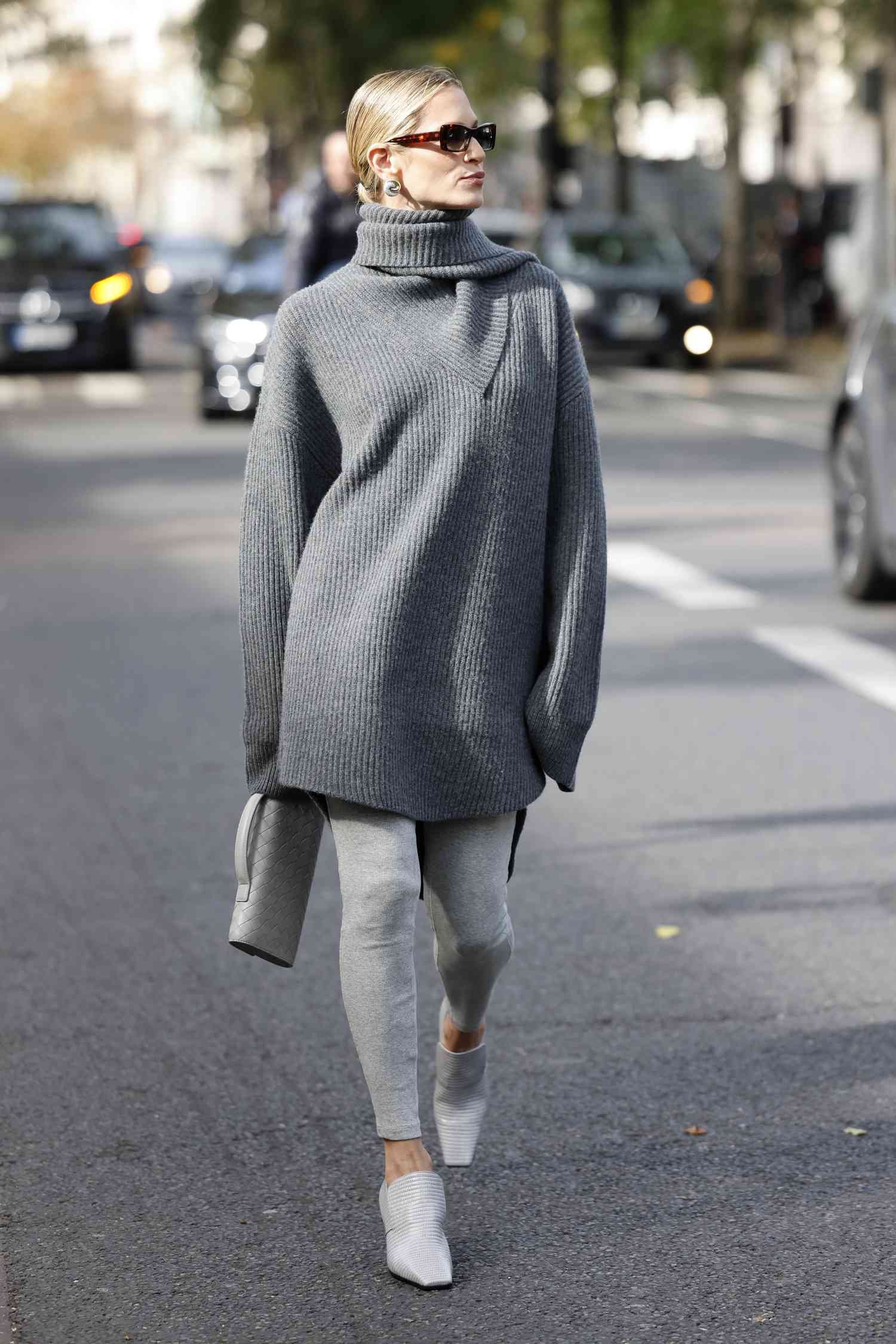 Helena Bordon wears Grey long sweater, grey leggings, grey loafers, grey Bottega Veneta bag, exterior Zimmermann, during Womenswear Spring/Summer 2025 as part of Paris Fashion Week