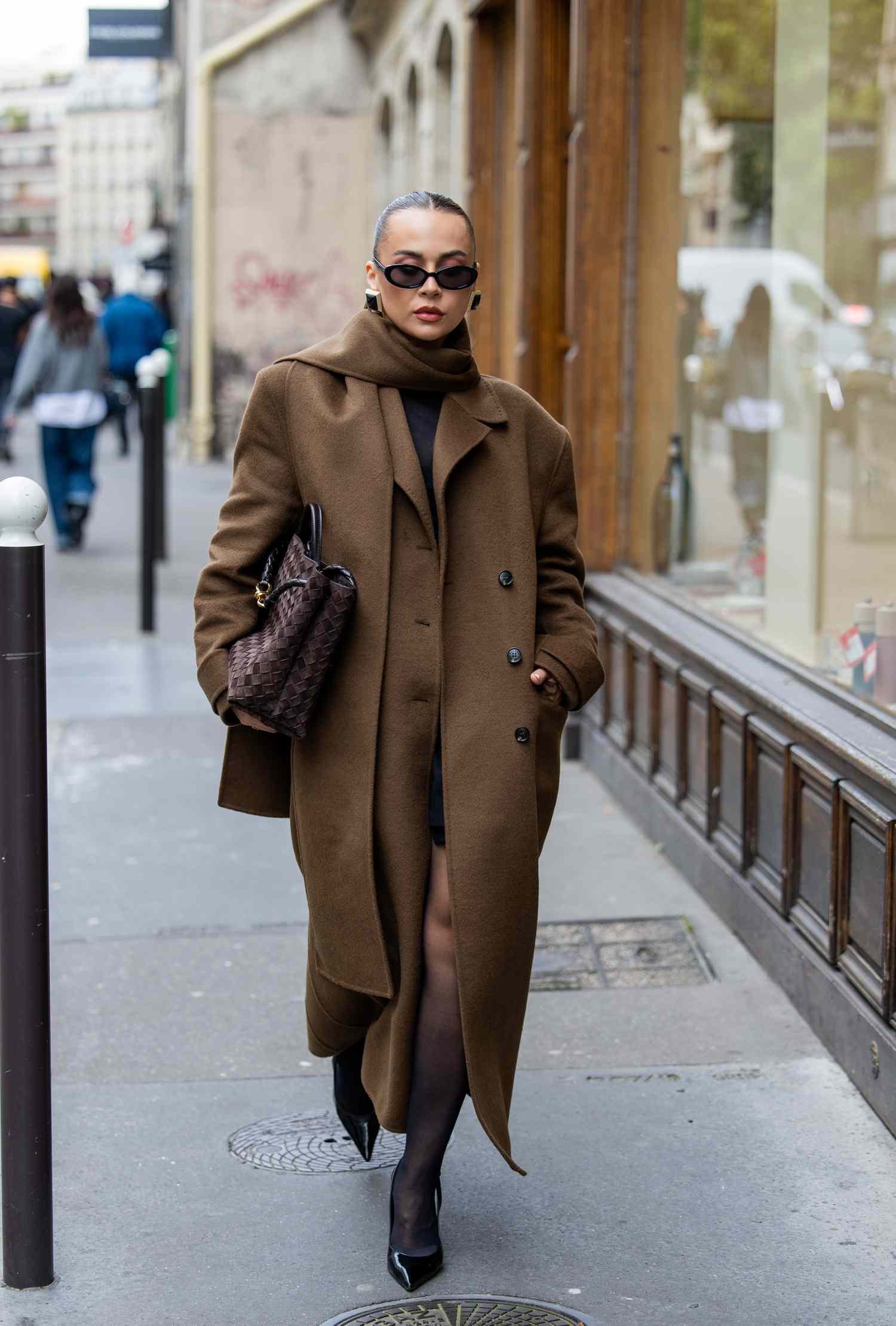 Anna Wein wears brown coat, bag, sunglasses outside Sacai during Womenswear Spring/Summer 2025 as portion of capital of France fashion Week