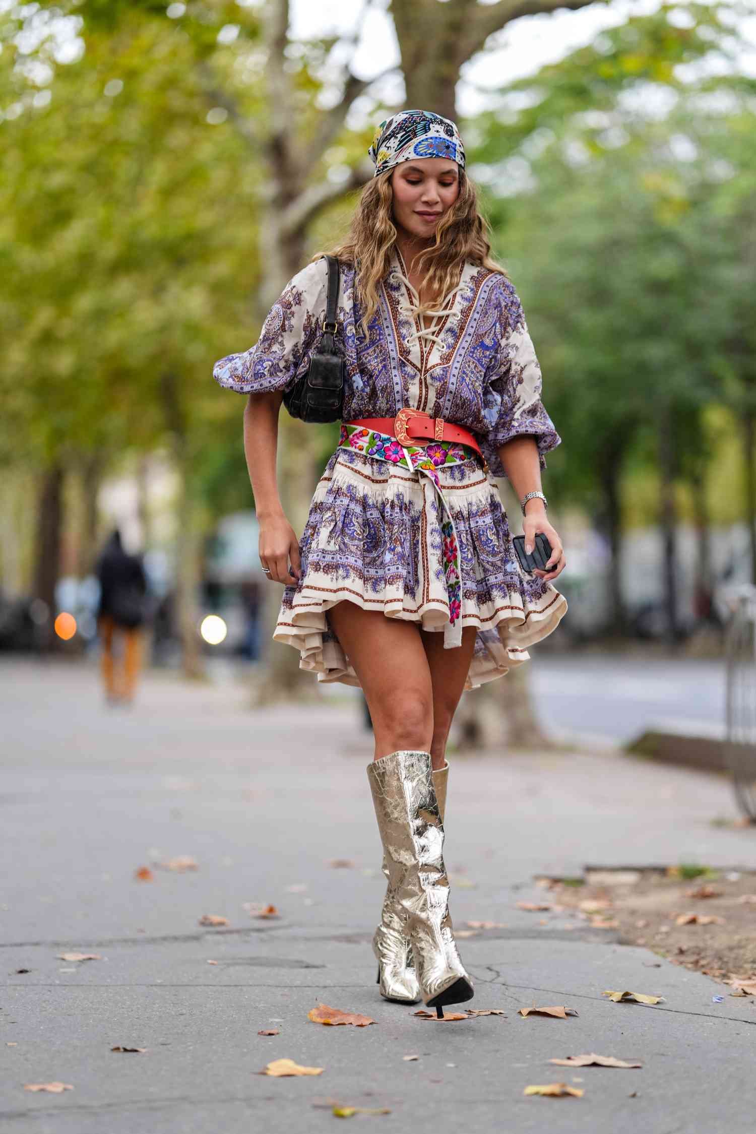 A guest wear blackness dark blue pattern/print caput scarf, white darkness blueness brownness pattern/print short sleeve mini dress, dark red leather belt, White person floral stitched belt, shiny gold point toe heel boots, angstrom unit silver watch, outside Zimmermann, during the Paris Fashion Week