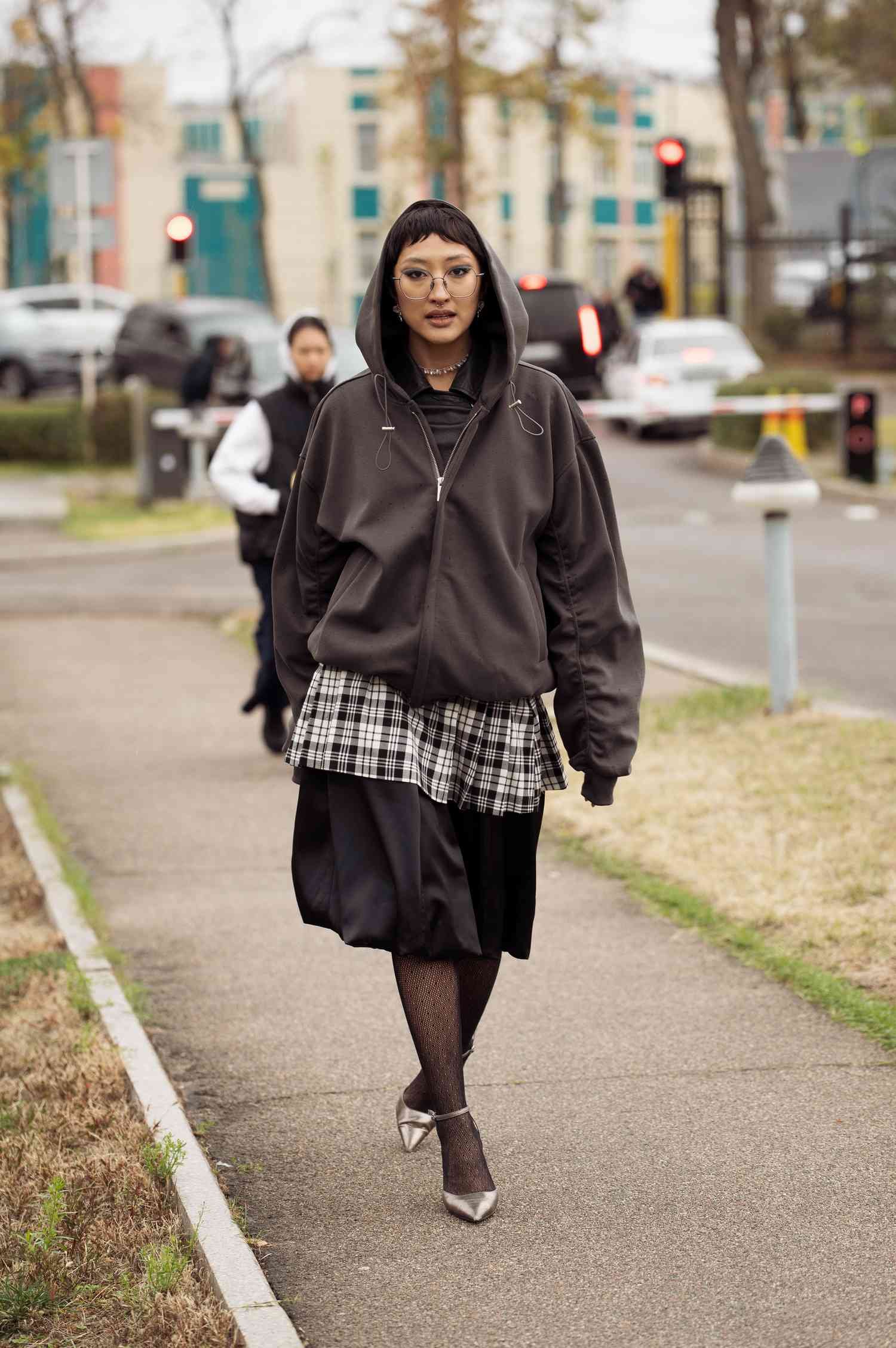 A invitee wears black balloon skirt, White and black checker shirt and Zane Grey hoodie, black leotards and Ag pointed shoes during the 10th season of the Visa manner Week Almaty on Oct 17, 2024 in Almaty, Kazakhstan.