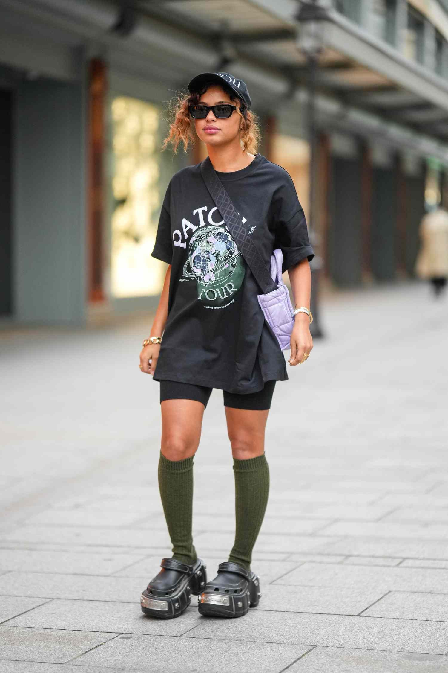 A adult female wears bike shorts and angstrom unit graphic tee